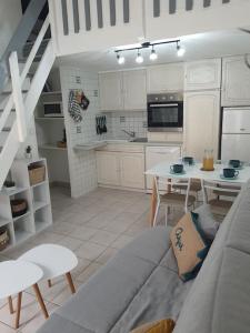 a kitchen with a couch and a table in a room at A 500 m de la plage, tout confort avec wifi in Le Barcarès