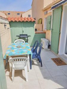 patio ze stołem i krzesłami na ganku w obiekcie A 500 m de la plage, tout confort avec wifi w mieście Le Barcarès