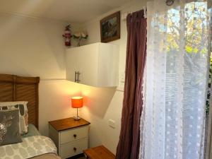 a bedroom with a bed and a window with a lamp at XYL Pets Friendly Opened Spacious Seaside Boutique Guesthouse in Caloundra