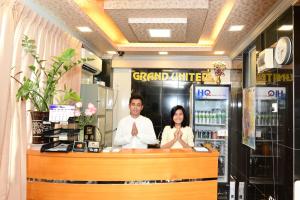 仰光大联合酒店 - 唐人街的站在柜台后面的男人和女人