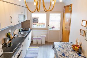 uma cozinha com um lavatório e um balcão em Surfness Lodge no Baleal