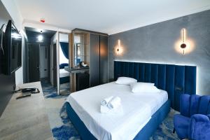 a hotel room with a bed with a blue headboard at HOTEL TOPAZ 4* CAP AURORA in Cap Aurora