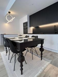 uma sala de jantar com uma mesa preta e cadeiras em Modern, City/Industrial Style em Ferizaj