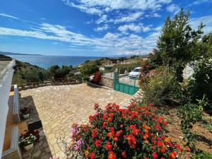 a view of the ocean from a house with flowers at Vila Paza in Sarandë