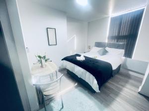 ein kleines Schlafzimmer mit einem Bett und einem Tisch in der Unterkunft Beautiful 1 bed apartment in Birmingham