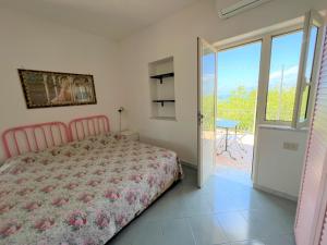 - une chambre avec un lit et une porte coulissante en verre dans l'établissement Appartamenti Miramare in Collina, à Ischia