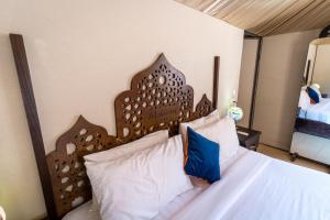 a bed with a wooden headboard in a bedroom at Aladdin Camp in Wadi Rum
