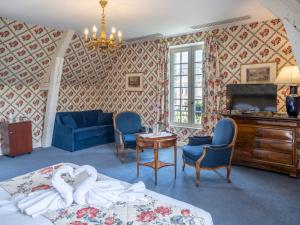 a bedroom with a bed and a tv and a table at Ch&acirc;teau D'artigny in Montbazon