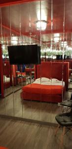 1 dormitorio con 1 cama roja en una habitación con sillas en KATRINA HOTEL, en Skaramangás