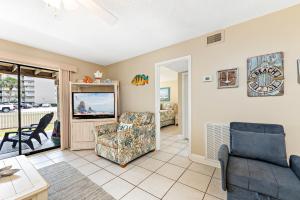 a living room with a couch and a tv at Seaside Beach & Racquet 2105 in Orange Beach