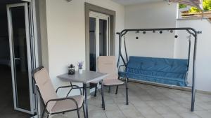 a table and chairs on a patio with a blue bench at Cesarica Studio near sea in Cesarica