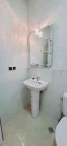 een badkamer met een wastafel, een spiegel en een toilet bij Agadir chez Omar in Agadir