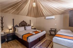 a bedroom with two beds in a tent at Aladdin Camp in Wadi Rum