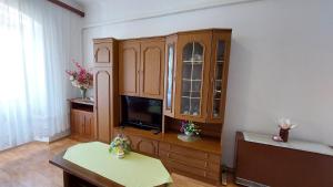 uma sala de estar com televisão e armários de madeira em Apartment Paulina em Opatija