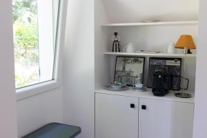 eine Küche mit weißen Schränken und einem Fenster in der Unterkunft La Métairie - Guesthouse in Orx