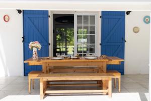 einem Tisch und Bänken vor einer blauen Tür in der Unterkunft La Métairie - Guesthouse in Orx