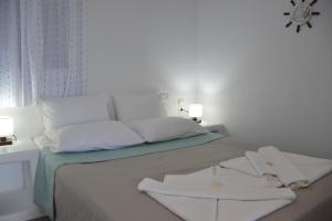 1 dormitorio con 1 cama y 2 toallas blancas en Aqua Vista Agia Kyriaki, en Agia Kiriaki Beach