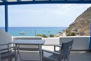 una mesa y sillas en un balcón con vistas al océano en Aqua Vista Agia Kyriaki, en Agia Kiriaki Beach