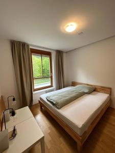 Schlafzimmer mit einem Bett, einem Tisch und einem Fenster in der Unterkunft Appartment Rosennock in Sankt Oswald