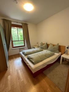 um quarto com uma cama grande e uma janela em Appartment Rosennock em Sankt Oswald