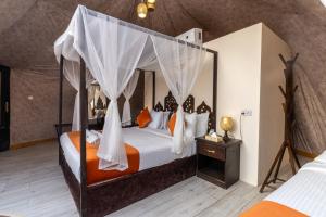 Aladdin Camp في وادي رم: غرفة نوم مع سرير مظلة في غرفة