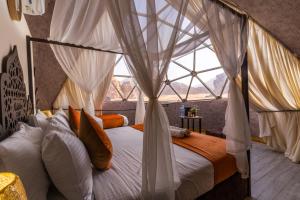 a bedroom with a canopy bed with a window at Aladdin Camp in Wadi Rum