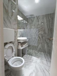 La salle de bains est pourvue d'une douche et de toilettes. dans l'établissement Garsoniera miky, à Deva