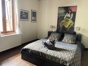 sypialnia z łóżkiem z dużym obrazem na ścianie w obiekcie Gîte de Solama avec SPA w mieście Balléville