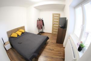 - une chambre avec un lit doté d'oreillers jaunes et une télévision dans l'établissement Dom Marhuľa, à Štúrovo