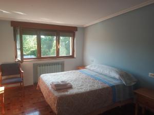 1 dormitorio con 1 cama, 1 silla y ventanas en Pensión ** Abacá Gijón, en Gijón