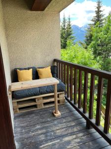a bed on the porch of a cabin at Studio Montagne - Plein Soleil et Terrasse in Briançon