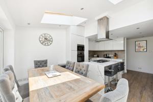 uma cozinha e sala de jantar com uma mesa de madeira e cadeiras em Richmond Riverside em Richmond upon Thames