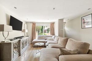 a living room with a couch and a flat screen tv at Richmond Riverside in Richmond upon Thames