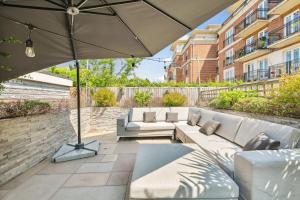 a patio with a couch and an umbrella at Richmond Riverside in Richmond upon Thames