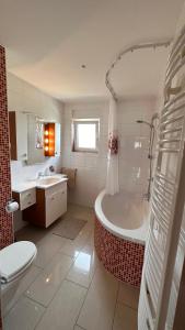 ein Badezimmer mit einer Badewanne, einem WC und einem Waschbecken in der Unterkunft 140 qm Haus Ideal für Familien und Messebesucher in Heusenstamm