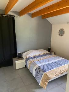 een slaapkamer met een bed en een houten plafond bij Appartement familial à Crots in Crots