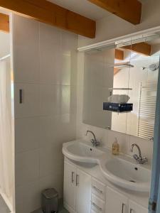 een witte badkamer met een wastafel en een spiegel bij Appartement familial à Crots in Crots