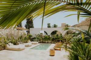 a swimming pool in a courtyard with plants at Hotel Anilevich Mansion in Beer Sheva