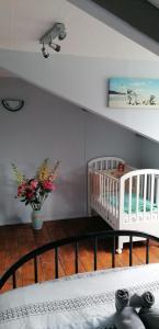 a room with two cribs and a vase of flowers at Petite maison de vacances in Pléneuf-Val-André