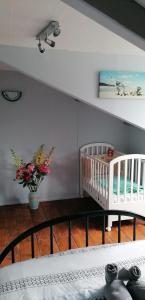 een kamer met 2 wiegjes en een vaas met bloemen bij Petite maison de vacances in Pléneuf-Val-André