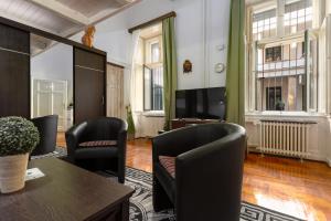 a living room with chairs and a table and a tv at Home City Center Terrace Apartment in Budapest