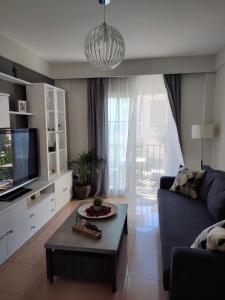 salon z kanapą i telewizorem w obiekcie Apartamento turístico Azahara w mieście Nerja