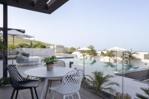 a patio with a table and chairs and a pool at Alaia Resort- Had Nes אלאיה ריזורט - חד נס in Had Nes