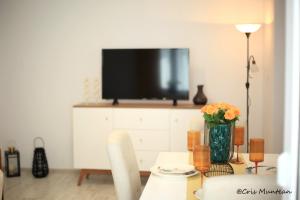 a living room with a table with a television on a cabinet at ULO Residence in Alba Iulia +9 photos