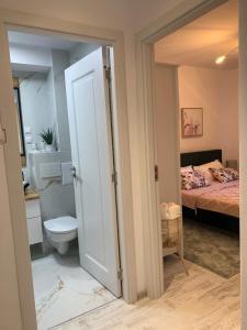 a bathroom with a bed and a toilet in a room at ULO Residence in Alba Iulia