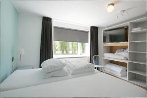 デン・ヘルダーにあるPakhuys Lodge - Oudのベッドルーム(大きな白いベッド1台、窓付)