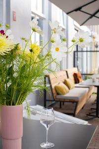 een vaas met bloemen op een tafel met een wijnglas bij Boutiquehotel Princenjagt in Middelburg