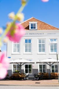 a hotel with tables and umbrellas in front of it at Boutiquehotel Princenjagt in Middelburg