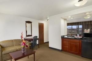 a living room with a couch and a desk at Ramada by Wyndham Tukwila Southcenter in Tukwila