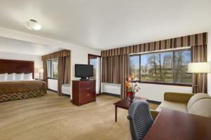 a hotel room with a bed and a television at Ramada by Wyndham Tukwila Southcenter in Tukwila